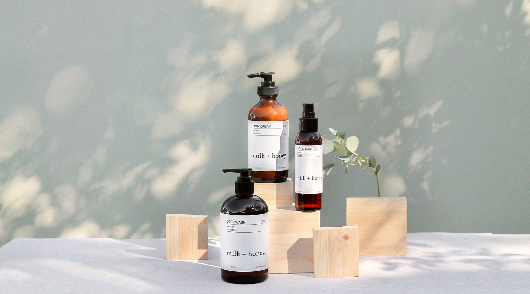 Set of skincare products with 'milk + honey' branding on a neutral background