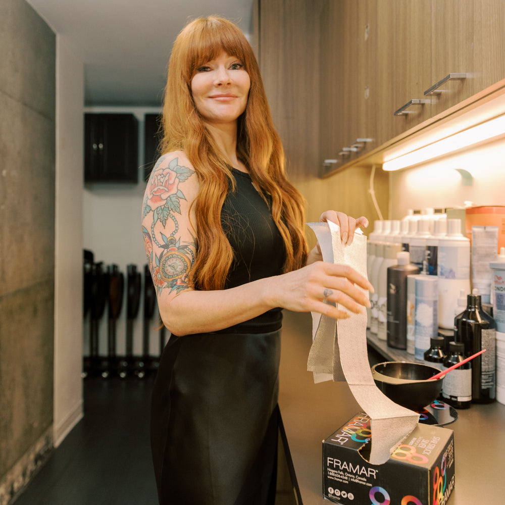 Woman with tattoos holding a product in a kitchen setting