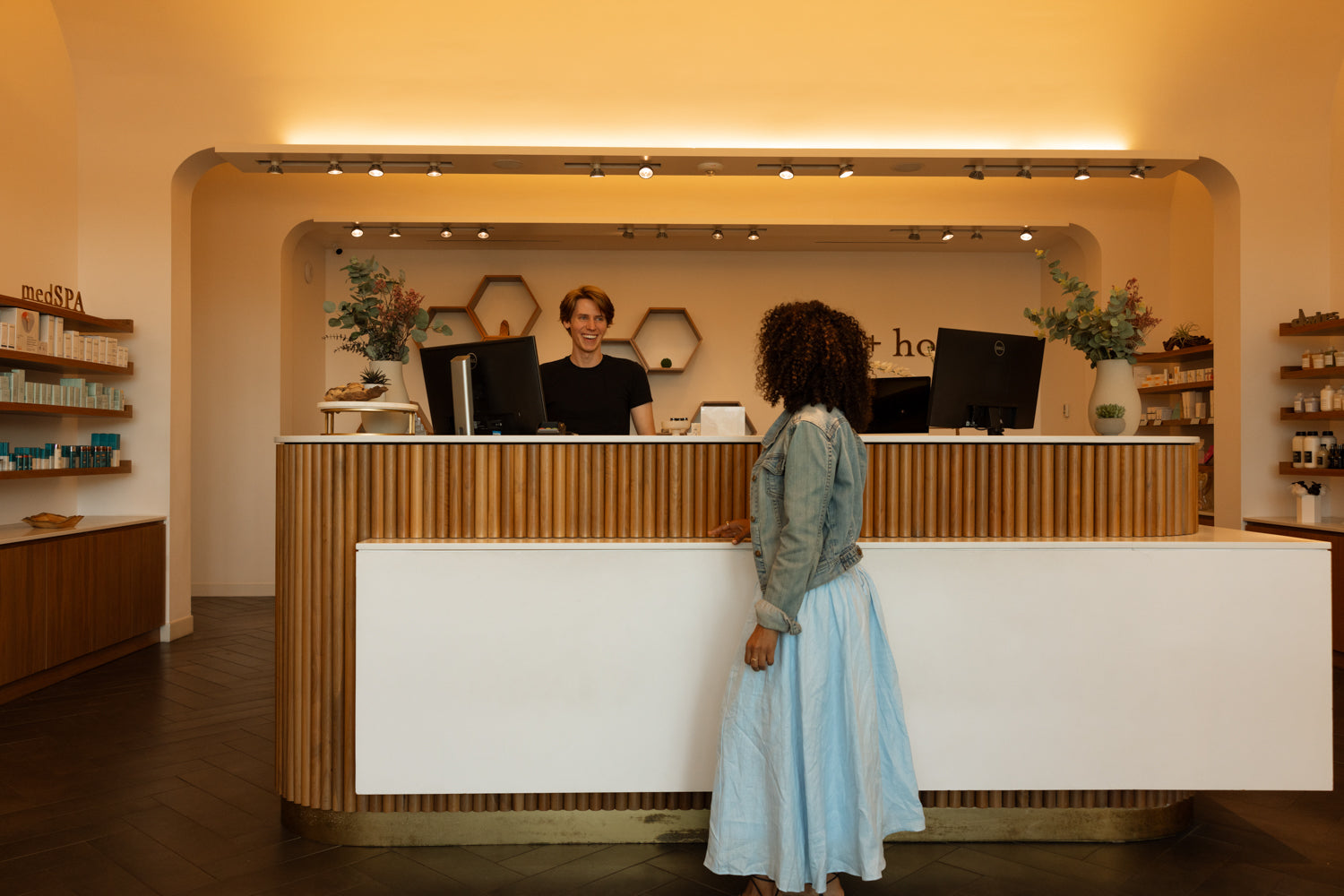 Person standing at a reception desk in a modern office setting