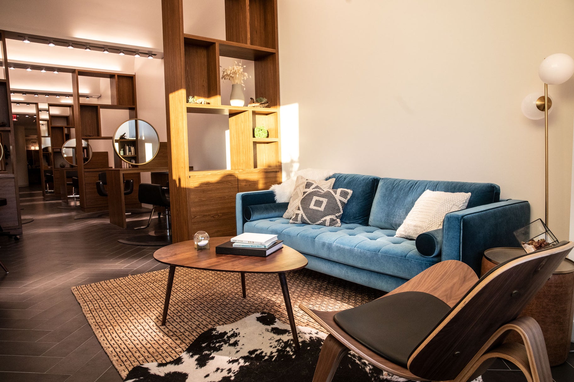 Modern living room with blue sofa, wooden coffee table, and decorative items.