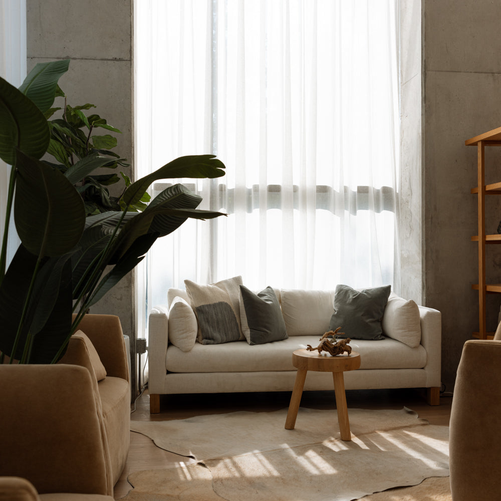 Modern living room with beige sofa, armchairs, and a coffee table.