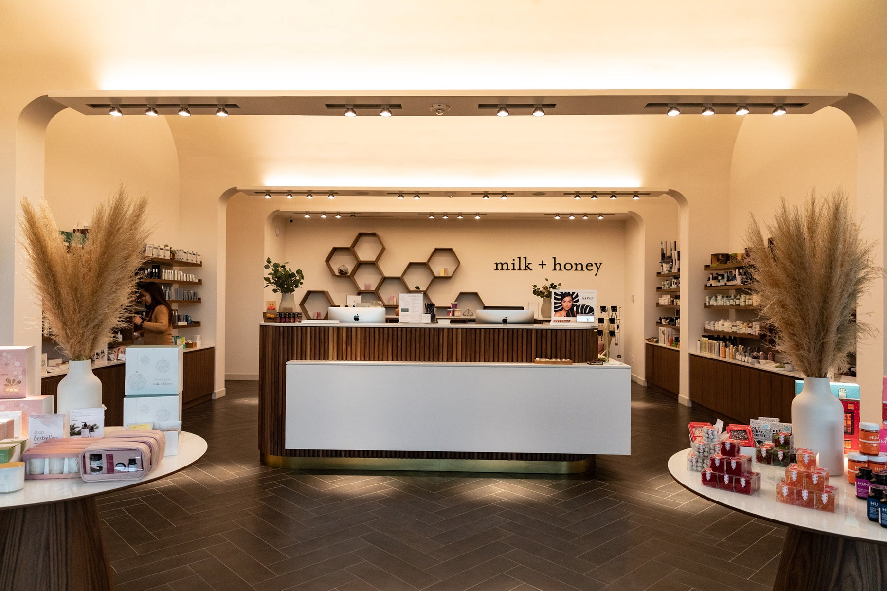 Store interior with a reception desk and 'milk + honey' branding.