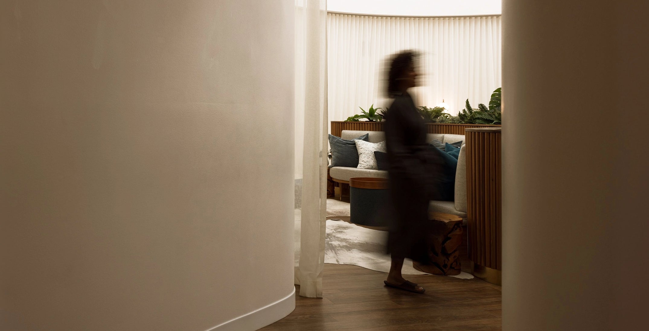 Person walking through a modern living room with neutral tones