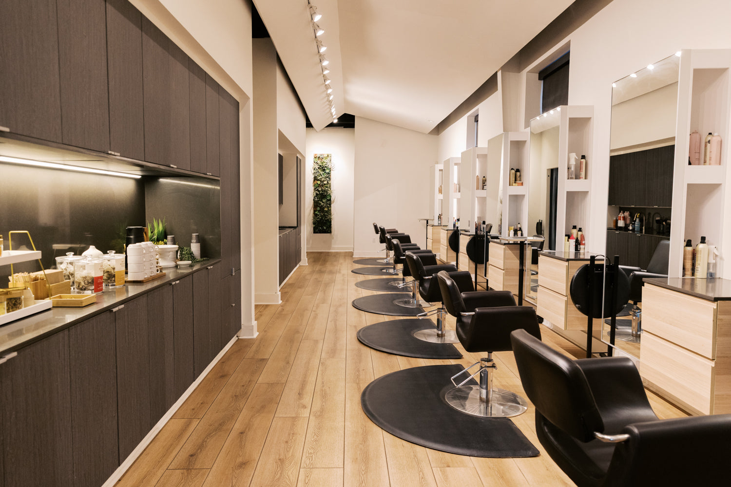 Modern hair salon interior with black chairs and wooden floors